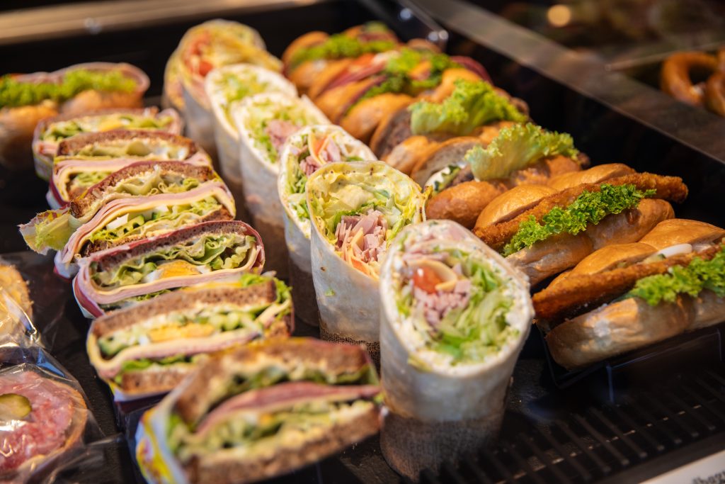 Various snacks, sandwiches with ham, salad, cheese and butter